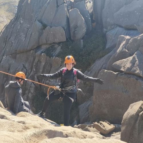 Participante realizando rapel no Pico das Agulhas Negras durante experiência de montanhismo da Rota Elementar.