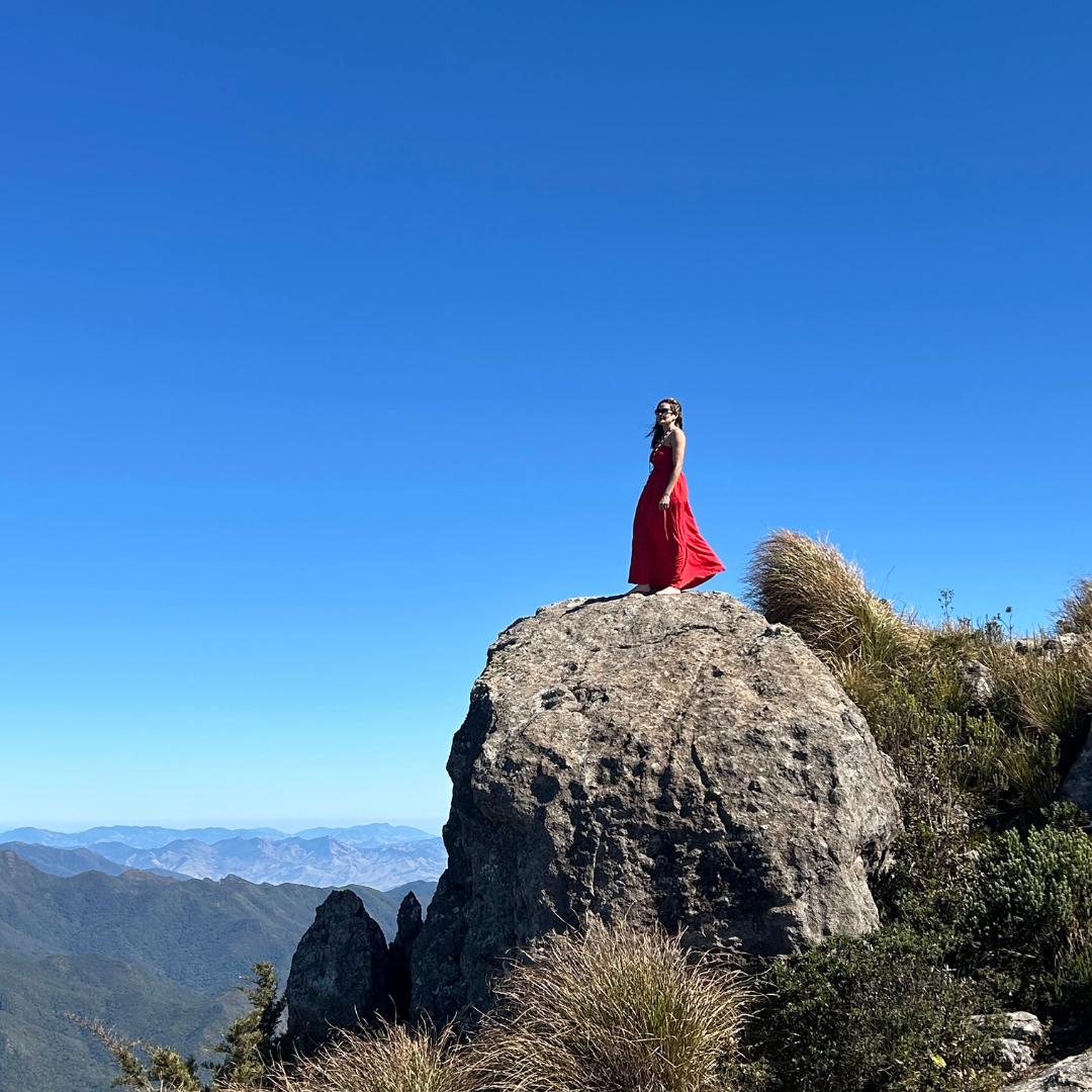 Caminhada leve pelo Planalto do Itatiaia em direção à imensa formação rochosa da Pedra Furada, cercada por vegetação típica de altitude.